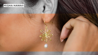 Earring with flower design and pearl, illustrating how to tell if pearl jewelry is real.