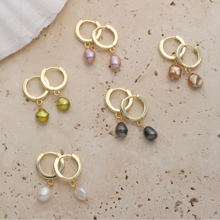 Hoops and huggies earrings featuring colorful pearls and gold hoops on a neutral background.