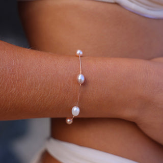 Model wearing Mari multicolor pearl bracelet in 14kt  rose gold by Misha Hawaii