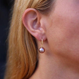 Pink Pearl Drop Earrings in gold on ear