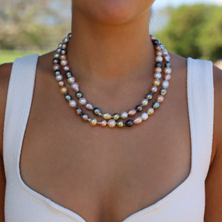 Woman wearing 38 inch rainbow pearl rope strand doubled at the collarbone, Misha Hawaii
