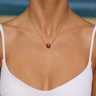 Woman wearing floating AAA pink pearl necklace, Misha Hawaii