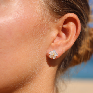 Model wearing Pua mother of Pearl flower studs in gold 