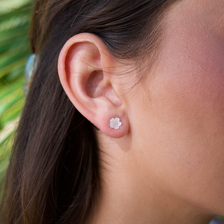 Tiny Plumeria mother of Pearl Stud Earrings in Gold on model ear