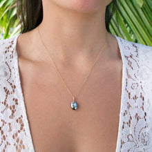 画像をギャラリービューアに読み込む, Necklace with a pendant worn by a person against a blurred green background