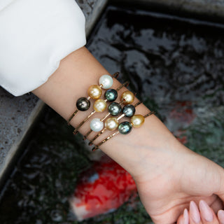 multicolor pearl bangle, tahitian pearls and golden south sea pearls float on gold bangle on model