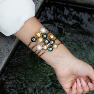 multicolor pearl bangle, tahitian pearls and golden south sea pearls float on gold bangle on model