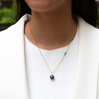 Model wearing a Tahitian black pearl necklace in gold handcrafted in Hawaii