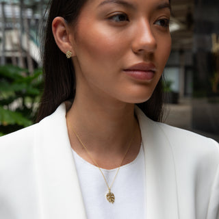monstera stud earrings in gold with cubic zirconia on model