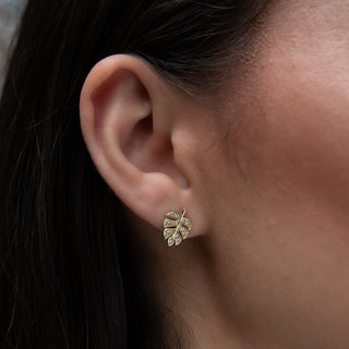 monstera stud earrings in gold with cubic zirconia on model
