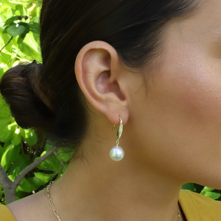 White Pearl Drop Earrings on a gold earwire with cubic zirconia on model