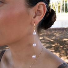 画像をギャラリービューアに読み込む, Close-up of a woman wearing pearl earrings with a blurred natural background