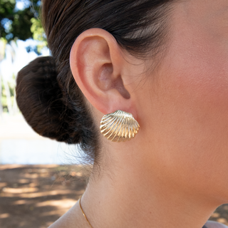 Close-up of a woman wearing Samara shell stud earrings, showcasing the vintage style and gold vermeil finish.