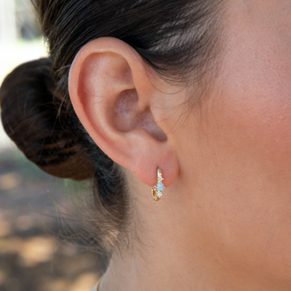 Opal Huggies in gold on ear