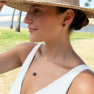 Model wearing a Tahitian black pearl necklace in gold handcrafted in Hawaii