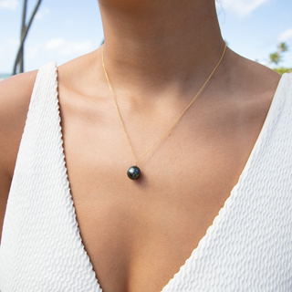 Model wearing a Tahitian black pearl necklace in gold handcrafted in Hawaii