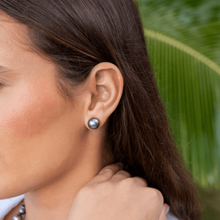 Model wearing a Tahitian black pearl stud earrings by Misha Hawaii