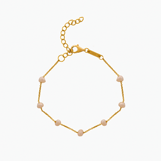 Gold bracelet with pink beads on a white background