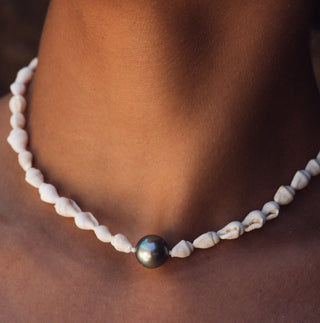 Model wearing a Shell and Tahitian black pearl necklace in gold handcrafted in Hawaii