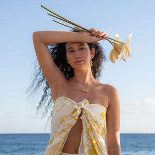 Model wearing Puakenikeni flower necklace in gold handcrafted in Hawaii far away