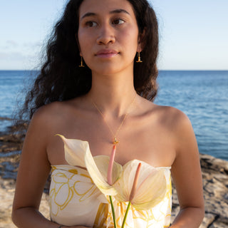 Model wearing Puakenikeni flower earrings in gold handcrafted in Hawaii