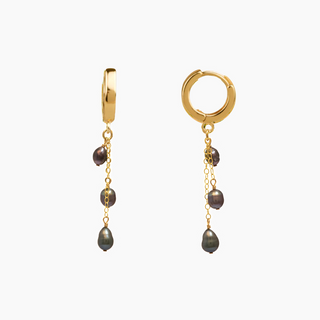 Gold hoop earrings with dangling tahitian keshi pearls on a white background
