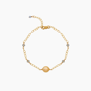 Gold bracelet with a golden south sea pearl and aquamarine gemstones on a white background
