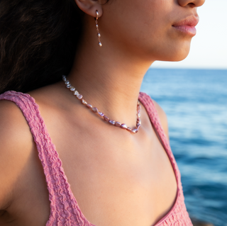 Model wearing an Ombré Pink Keshi Strand showcasing pink keshi pearl strand by the sea, capturing elegance and beauty.