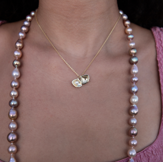 gold shell necklace with pearl inside on model