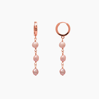 Rose gold earrings with pearl beads on a white background