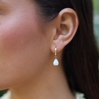 Woman wearing white pikake huggie earrings, Misha Hawaii