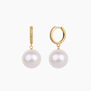 A pair of gold hoop earrings with a vertical bar of small clear stones and a dangling white pearl, shown on a light gray background.