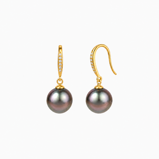 A pair of gold drop earrings featuring a small pavé-set clear stone above a round, dark gray-black pearl, shown on a plain white background.