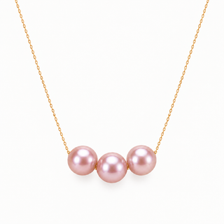 A delicate gold chain necklace featuring three smooth, lustrous pink pearls aligned horizontally at the center, set against a clean white background.