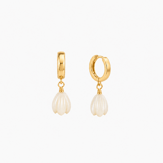 A pair of gold huggie hoop earrings with a dangling textured white pearl drop, shown on a clean white background.