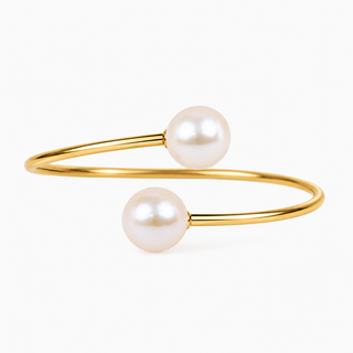 A gold open cuff bracelet featuring two smooth, lustrous white pearls, shown on a clean white background.