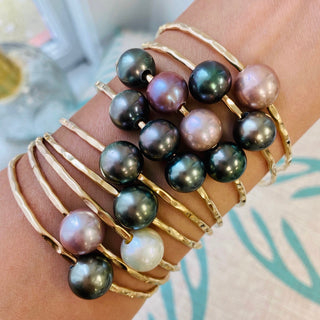 set of nine pearl bangles in gold on wrist