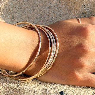 Gold hammered bangles on wrist