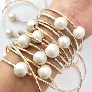 White pearl bangle in gold made in Hawaii on wrist