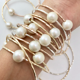 white pearl bangles in gold on wrist