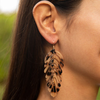 Woman wearing banana leaf statement drop earrings, Misha Hawaii